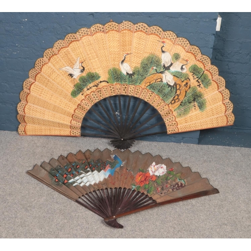 527 - Two large hand painted oriental fans. One decorated with cranes, the other with peacocks. (Largest 9... 