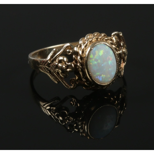 560 - A 9ct gold opal ring with open work shoulders. Size N. 2.45g.