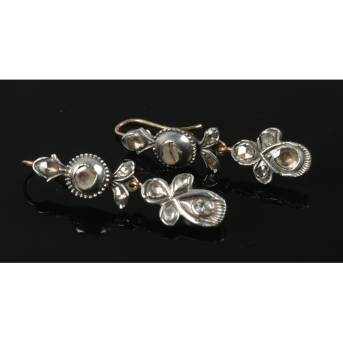 561 - A pair of antique white metal and diamond drop earrings.