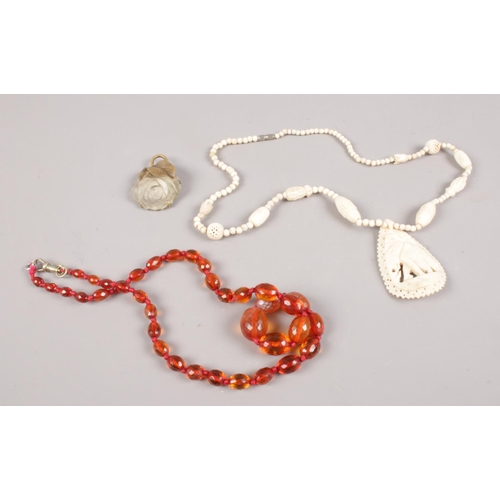 564 - A small collection of jewellery. Includes amber coloured beads, carved bone necklace and a frosted g... 