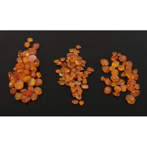 603 - A collection of assorted polished amber necklace beads ranging in color from cognac through to butte... 