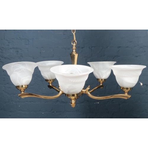 543 - A 5 arm brass chandelier with glass bowl shades.