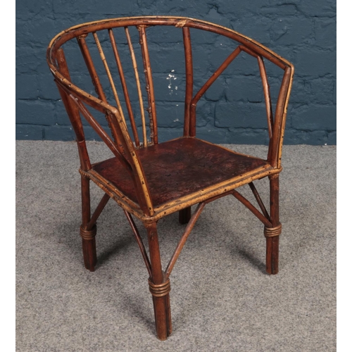 545 - A child's Bamboo & hardwood chair with leather patterned seat. H: 48cm, W: 39cm, D: 26cm.