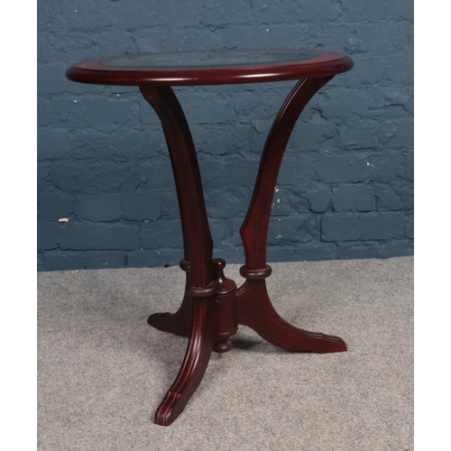 388 - A Mahogany round glass topped occasional table. Comprising of bevelled glass and three legs.  H: 62c... 