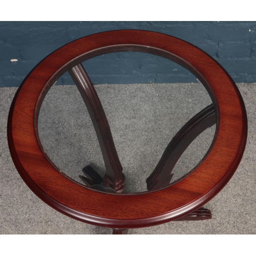 388 - A Mahogany round glass topped occasional table. Comprising of bevelled glass and three legs.  H: 62c... 