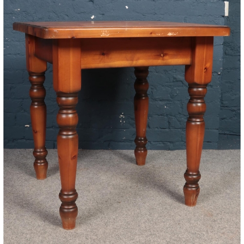 394 - A stained square Pine kitchen table with turned legs. H: 80cm, W:76.5cm, D:76cm.