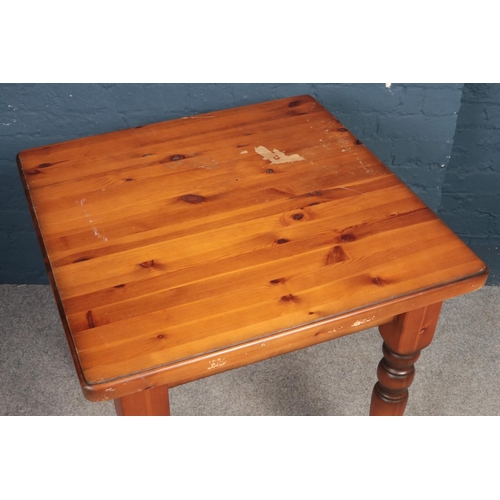 394 - A stained square Pine kitchen table with turned legs. H: 80cm, W:76.5cm, D:76cm.