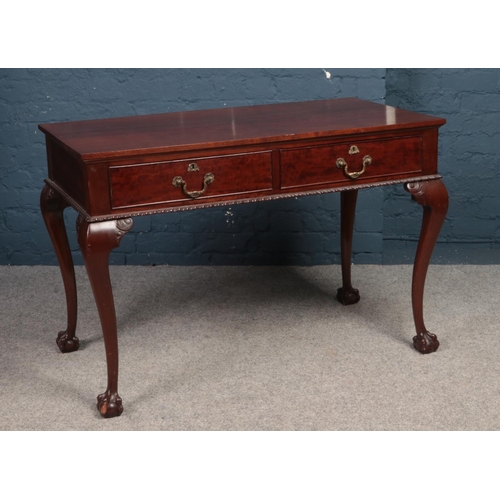 399 - A Mahogany 2 drawer writing table with cabriole legs & ball claw feet. (furniture makers stamp to in... 