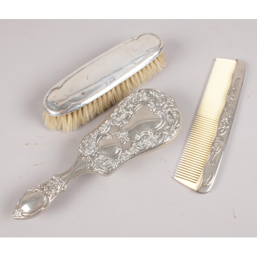 434 - A silver mounted brush along with a white metal comb and hair brush. Assayed Chester 1922.