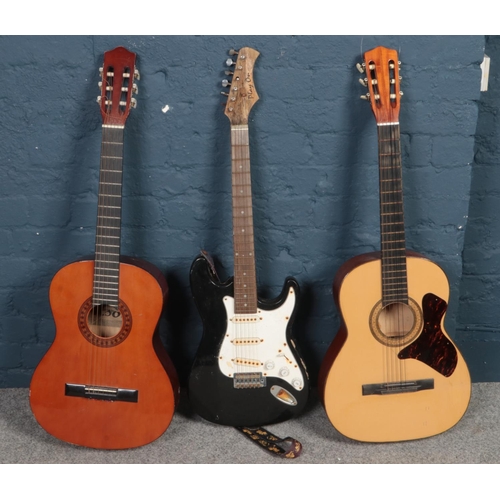 498 - Two acoustic guitars along with a Stratocaster style electric guitar.