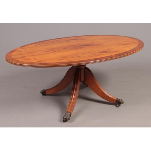 318 - A yew wood centre pedestal oval coffee table.