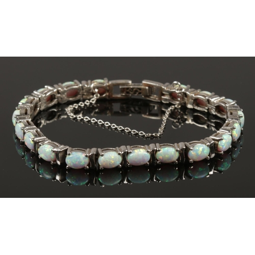 220 - A silver and opal line bracelet with safety chain.