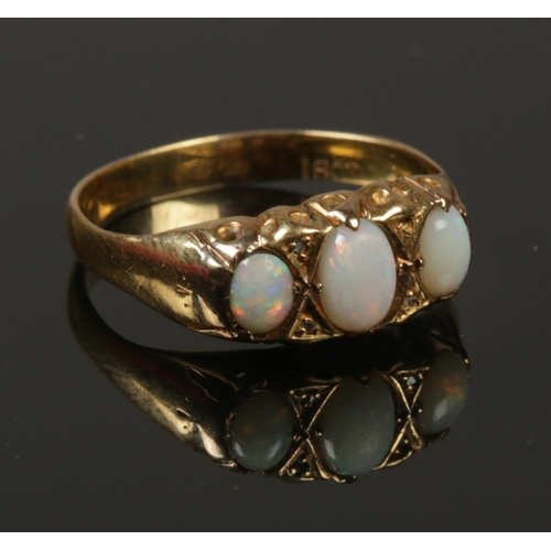 223 - An 18ct gold, diamond and three stone opal ring. Size N 1/2. 2.15g.