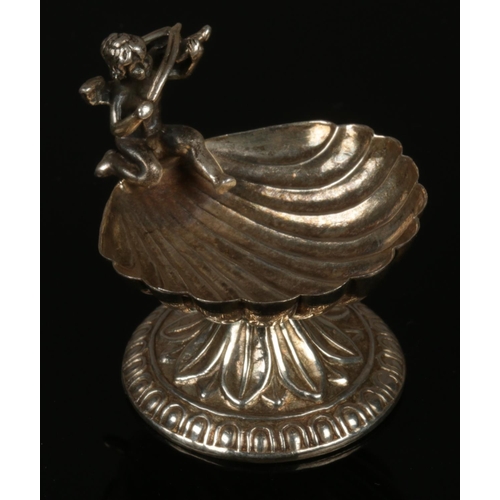 280 - A Silver salt dish formed as a shell with cherub design. (4.5 cm height)