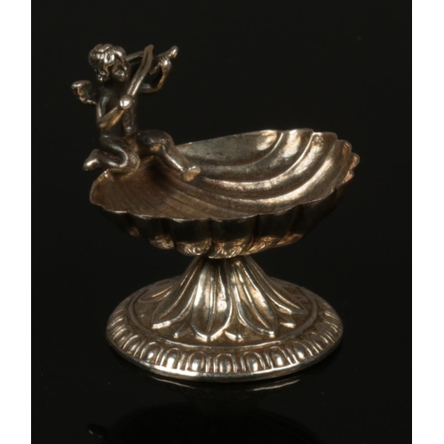 280 - A Silver salt dish formed as a shell with cherub design. (4.5 cm height)