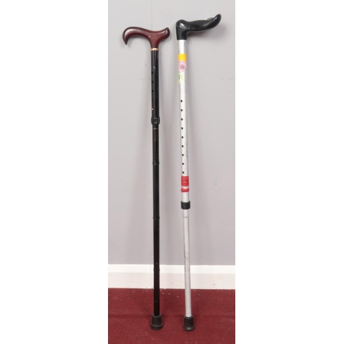 384 - Two modern style adjustable walking sticks.