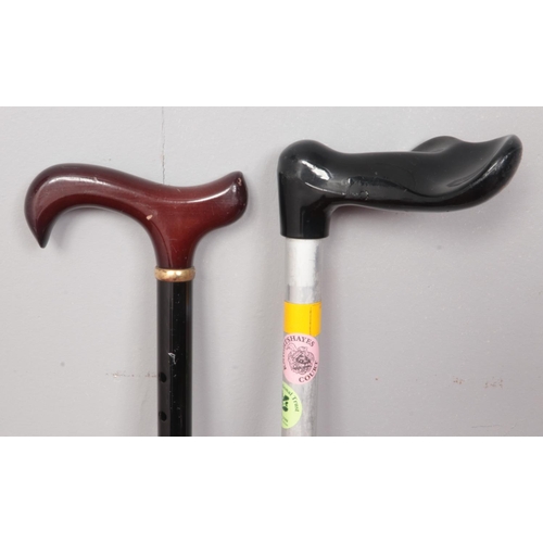 384 - Two modern style adjustable walking sticks.