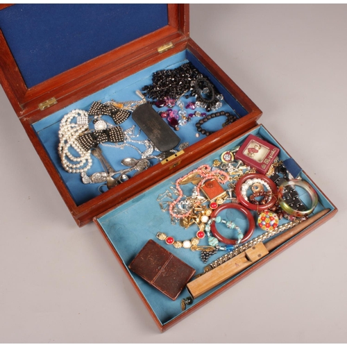 92 - A cutlery box with contents of costume jewellery, collector's spoons etc.