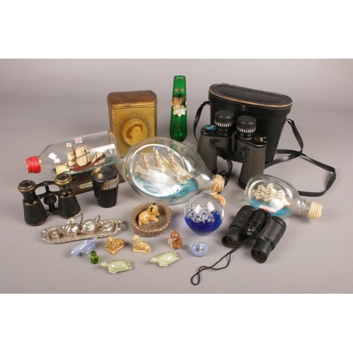 118 - A box of collectables. Includes binoculars, Wade Whimsies, ships in bottles etc.