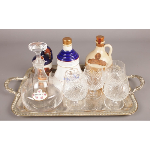 136 - A silver plate tray with contents. Includes full and sealed Bells whisky decanter, Yorshire Liqueur ... 