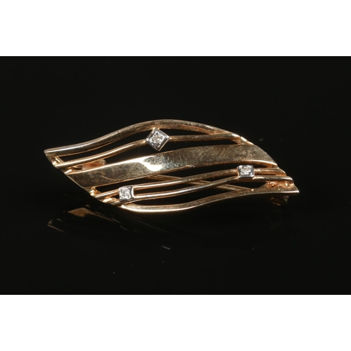 246 - A 9ct gold brooch set with three small diamonds. 2.37g.