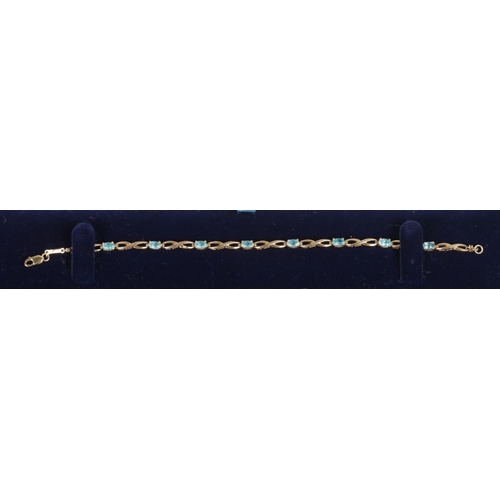 251 - A 9ct gold and blue topaz bracelet, with diamond accent.