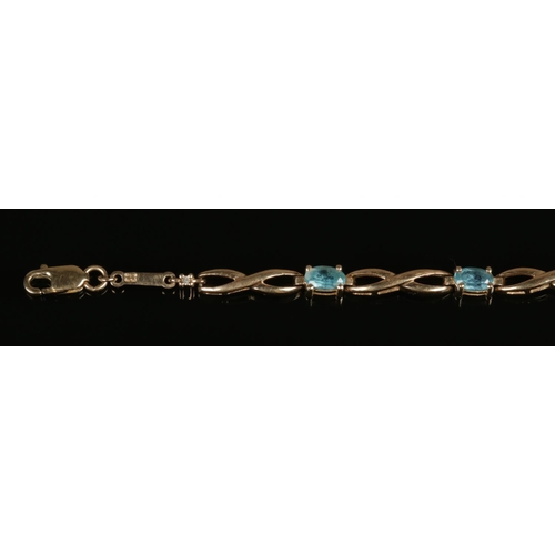 251 - A 9ct gold and blue topaz bracelet, with diamond accent.