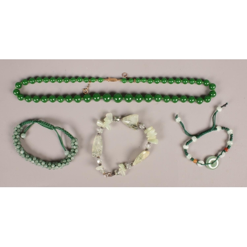 275 - A green hardstone bead necklace with 9ct gold clasp, along with three hardstone bracelets.