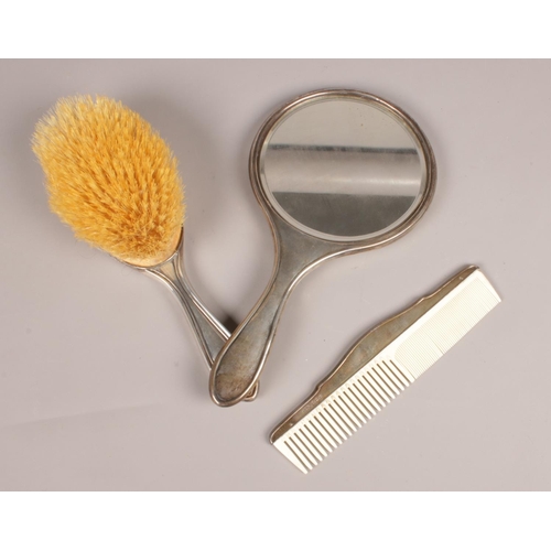 287 - A silver bedroom set. Hairbrush, comb, hand mirror, assayed Birmingham various maker marks.