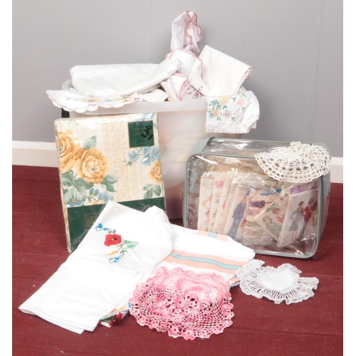 497 - A collection of linens. Tablecloths, curtains, doilies. To include dress making patterns