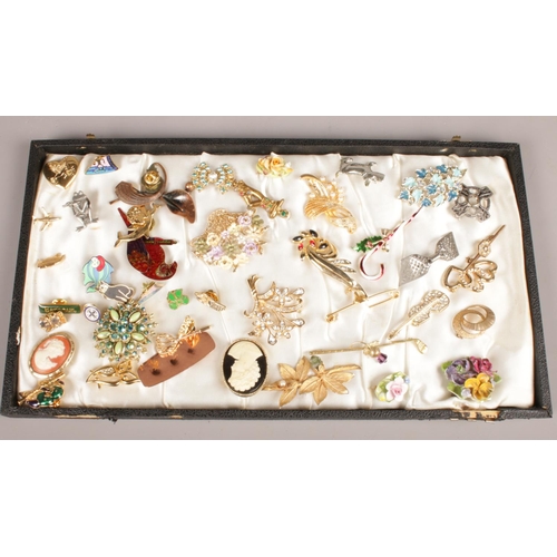 126 - A tray of costume brooches and pin badges. Including coloured paste set examples, etc.