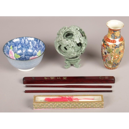 63 - A group of orientalwares. Including puzzle ball on stand, small vase, hand fan, etc.