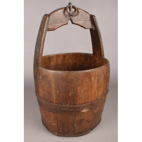 383 - An antique wooden well water bucket with metal mounts.