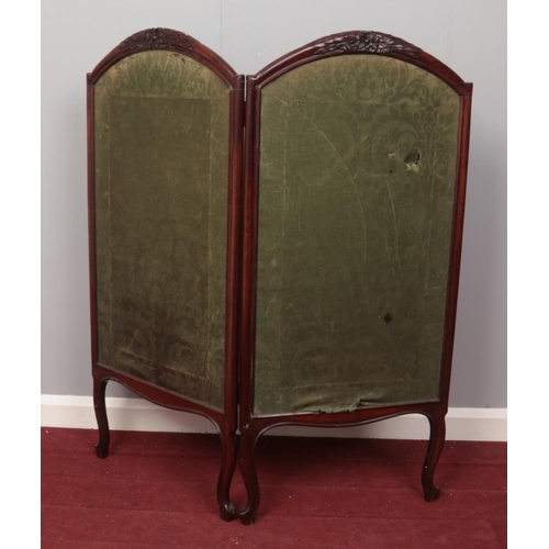 415 - A Mahogany carved and framed two panelled screen. Comprising of a decorative green material on each ... 