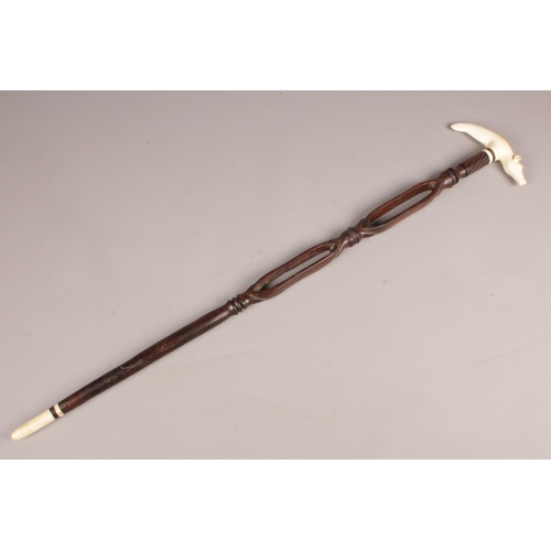 86 - An African tribal carved wooden stick with ivory handle formed as a cow.