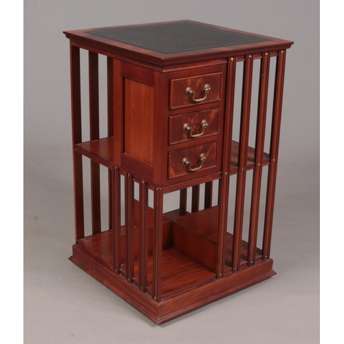 303 - A mahogany revolving bookcase with leather inset top and three drawers. (79cm x 49cm x 49cm)