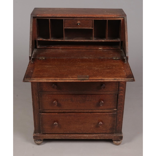 332 - An oak bureau with fitted interior and four drawers.