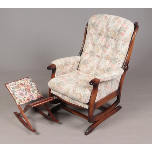 343 - A floral upholstered rocking chair. To include a gout stool (102cm height x 58cm width)