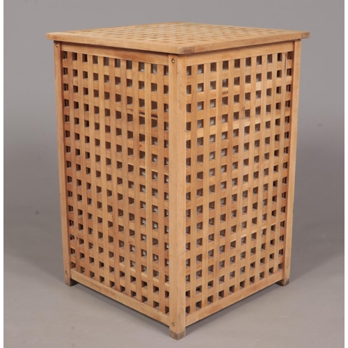 345 - A wooden laundry basket with pull up lid and cotton bag inside. (68cm height x 46.5cm width).