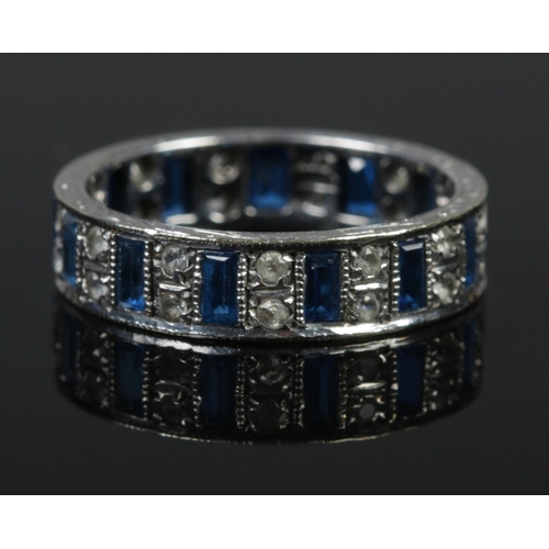 366 - A 9ct white gold eternity ring set with blue and clear stones. Size R. 4.6g.