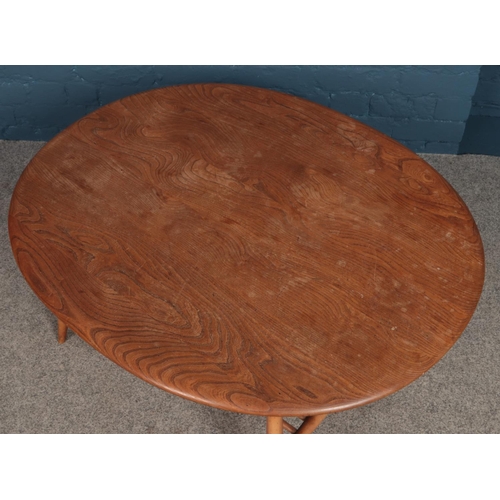 446 - An Ercol oval coffee table with magazine rack under tier.