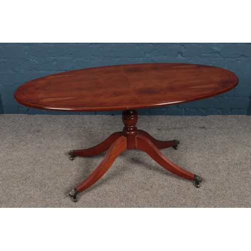 461 - A Regency style yew wood oval coffee table. (49cm height 100cm width)