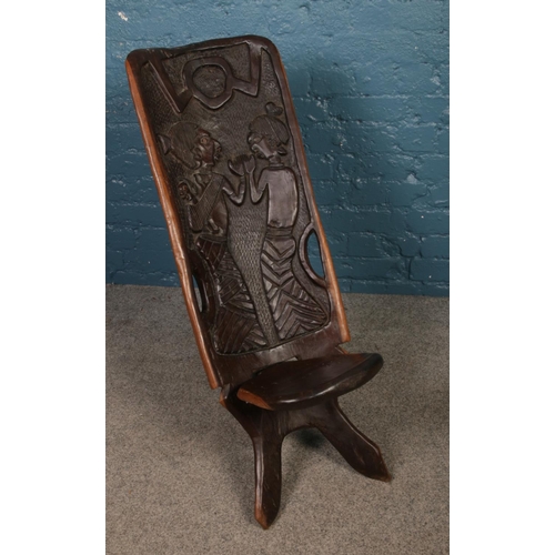 234 - An African hardwood birthing chair. The back is carved with two figures and baby. H: 89cm W: 35cm.