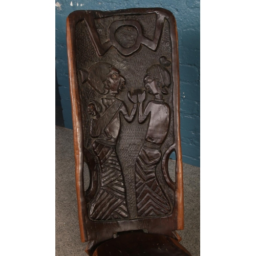 234 - An African hardwood birthing chair. The back is carved with two figures and baby. H: 89cm W: 35cm.