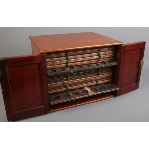 99 - A vintage mahogany coin chest with panelled doors.