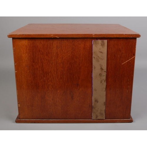 99 - A vintage mahogany coin chest with panelled doors.