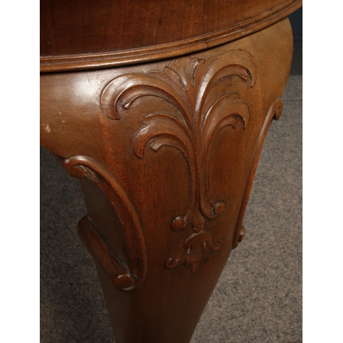 432 - A Victorian carved mahogany wind out dining table. With two extra leaves. Raised on carved ball and ... 