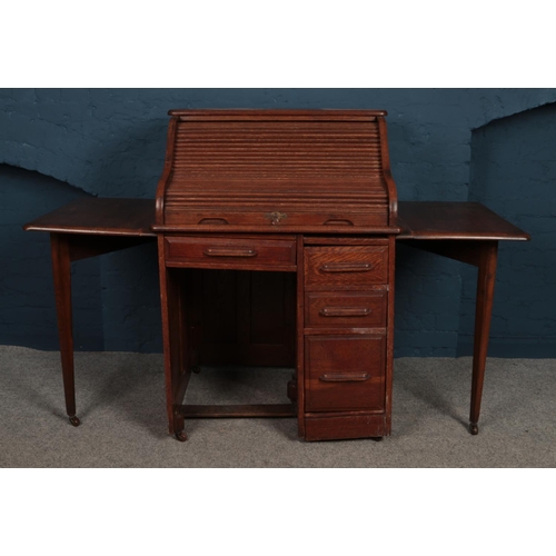 439 - An early 20th century oak roll top bureau with gate leg extensions. Raised on casters. H:117cm W:79c... 