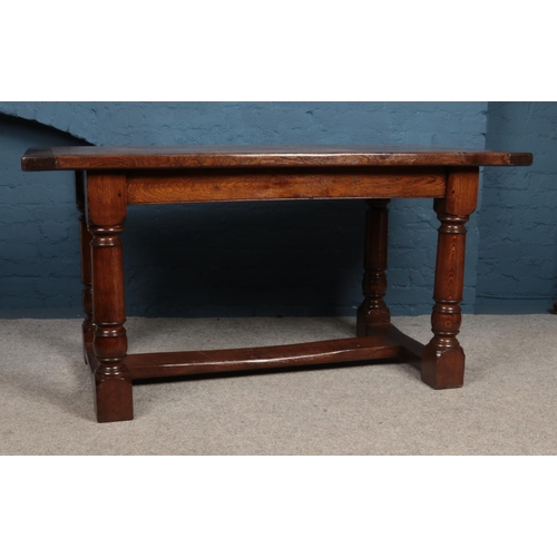 457 - An early 20th Century oak refectory style dining table. With four plank top on turned supports and s... 