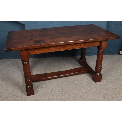 457 - An early 20th Century oak refectory style dining table. With four plank top on turned supports and s... 